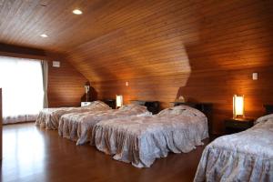 a group of four beds in a room with wooden walls at Esashi-gun - Cottage - Vacation STAY 38366v in Pinneshiri