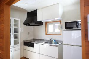 a white kitchen with a sink and a microwave at Esashi-gun - Cottage - Vacation STAY 38366v in Pinneshiri