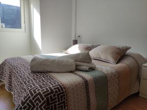 um quarto com uma cama com almofadas em Piso en Cedeira em Cedeira