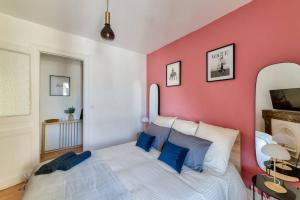 a bedroom with a large bed with a pink wall at Fibre - Le Haussmann LH - B'PAM in Le Havre