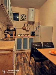 een keuken met een koelkast en een tafel met stoelen bij Plaza de petra in Wadi Musa