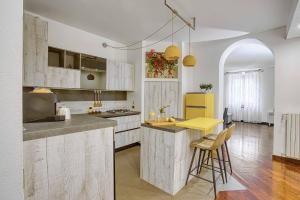 een keuken met witte kasten en een gele koelkast bij Casa Tricolore in Milaan