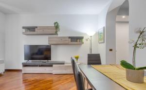 een woonkamer met een eettafel en een televisie bij Casa Tricolore in Milaan
