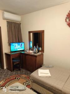 een hotelkamer met een bed en een bureau met een televisie bij Plaza de petra in Wadi Musa