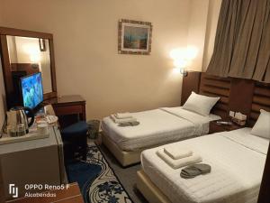 een hotelkamer met twee bedden en een televisie bij Plaza de petra in Wadi Musa