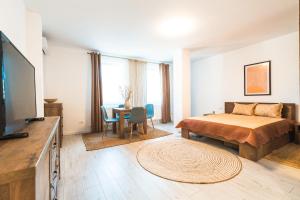 a bedroom with a bed and a table with chairs at EVRA APARTMENTS in Recaş