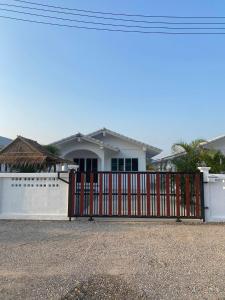 a white house with a red gate in front of it at S&F villa in Sam Roi Yot