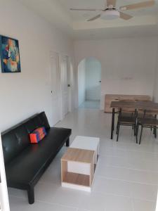 sala de estar con sofá negro y mesa en S&F villa, en Sam Roi Yot