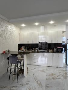 a kitchen with white cabinets and a table in it at Apartment in centre of Yerevan in Yerevan