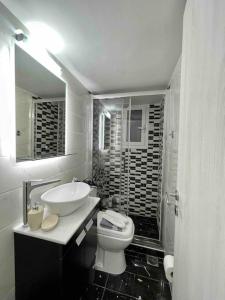 a white bathroom with a sink and a toilet at ATH Luxury Central apartment in Athens