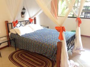 a bedroom with a bed with orange bows at Outpost Lodge in Arusha