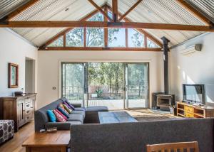 uma sala de estar com um sofá e uma televisão em Huge house Your Hunter Valley Wine Staycation ! em Pokolbin