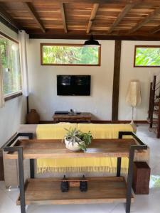 Una sala de estar con un sofá amarillo y una mesa. en Pousada. Espatódea, en Petrópolis