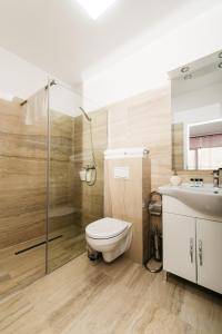 a bathroom with a toilet and a shower and a sink at EVRA APARTMENTS in Recaş