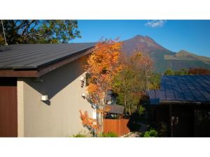a house with a roof with a mountain in the background at Innterhill Tsubasa Yufuin - Vacation STAY 94222v in Yufuin