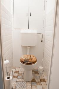 a bathroom with a toilet with a wooden seat at Városi Apartman in Pécs