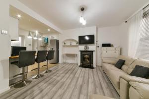 a living room with a couch and a fireplace at Bromley Palace - Entire 2 Bed House - Free Parking - Self Check-in in London