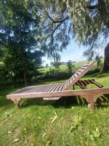 a wooden bench sitting in the grass under a tree at Ferienwohnung-Wenke in Tönning