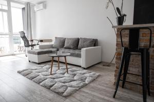 uma sala de estar com um sofá e uma mesa em Városi Apartman em Pécs