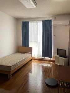 1 dormitorio con cama y ventana grande en Chambord Kyomachi 102-202 - Vacation STAY 97549v, en Kumamoto