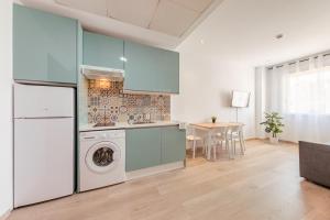 a kitchen with a washing machine and a table at Apartment with free parking and pool in Bormujos