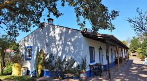 Biały budynek z niebieskim przycinaniem i drzewem w obiekcie Monte da Choça w mieście São Teotónio