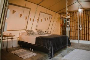 a bedroom with a bed in a tent at Serrano Tayrona Lodge in El Zaino