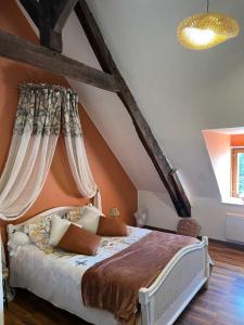 sypialnia z dużym łóżkiem na poddaszu w obiekcie La Ferme de Roulotte de Sandrine w mieście Carentoir