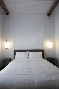 a bedroom with a large white bed with two lamps at Hotelia in Saint-Ambroise