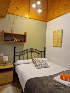 a bedroom with two beds and a wooden ceiling at Pensión O Muiño in O Pedrouzo