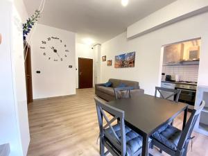 a living room with a table and a clock on the wall at Memory Suite con Wifi/Netflix in Bologna