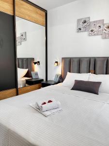 Schlafzimmer mit einem großen weißen Bett und einem Spiegel in der Unterkunft Kovacevic Apartments in Kotor