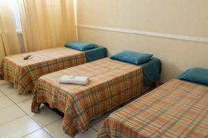 a hotel room with three beds in a room at ALVORADA PALACE HOTEL in Bauru