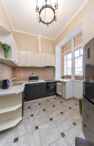 a kitchen with white cabinets and a tile floor at Khreschatyk. Maidan, Independence Square 2BR in Kyiv