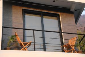 巴納哈契的住宿－Lahos Apartament B，阳台配有两把椅子和窗户。