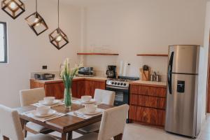 a kitchen with a wooden table and a stainless steel refrigerator at Lahos Apartament B in Panajachel