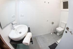 bagno bianco con lavandino e servizi igienici di DADO HOST a Vigo