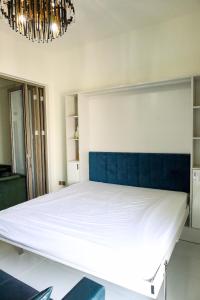 duże łóżko z niebieskim zagłówkiem w pokoju w obiekcie Luxury 1 bedroom apartment in Miraclz tower by Danube Properties w Dubaju
