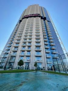 杜拜的住宿－Luxury 1 bedroom apartment in Miraclz tower by Danube Properties，一座高大的建筑,前面有一个游泳池