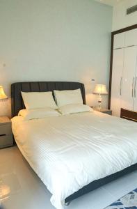 a large bed in a bedroom with two lamps at Luxury 1 bedroom apartment in Miraclz tower by Danube Properties in Dubai