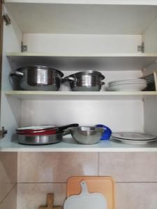 a shelf with pots and pans in a kitchen at Vesna Apartment in Ohrid