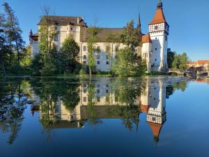 un castillo con su reflejo en el agua en Ubytování Pavel Voborník, en Blatná