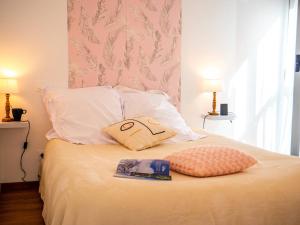 a bed with a pillow and a book on it at Les gites de Sylvie in Ussat