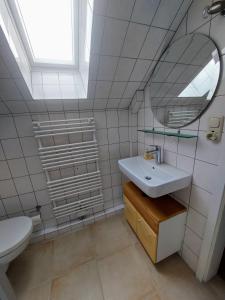a bathroom with a sink and a mirror and a toilet at Ferienwohnung-Volker in Tönning