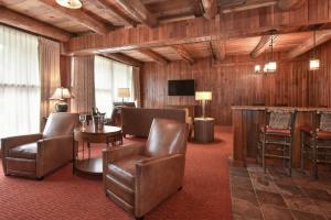 a hotel room with leather chairs and a television at Slopeside Hotel by Seven Springs Resort in Champion