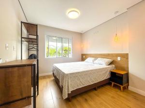 a bedroom with a large bed and a window at Apto com Wi-Fi a beira-mar em Santo SP in Santos