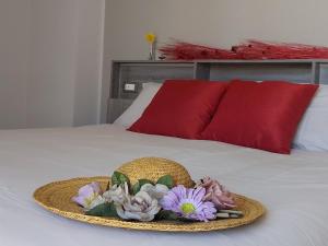 een strohoed en bloemen op een bed bij Roero Sunset in Govone