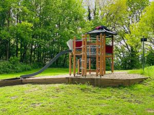 une aire de jeux avec un toboggan dans un parc dans l'établissement FeWo SONNENDECK Familien-strandnah-Garten-Hunde-Sport-und Schwimmbadnah-HansaPark, à Sierksdorf