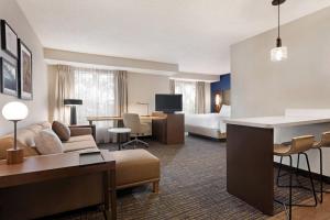 a hotel room with a bed and a living room at Residence Inn by Marriott Roseville in Roseville