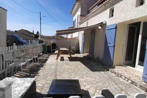 patio ze stołem piknikowym i ławkami obok budynku w obiekcie Maison de vacances 3 chambres avec terrasses w mieście Saint-Georges-de-Didonne